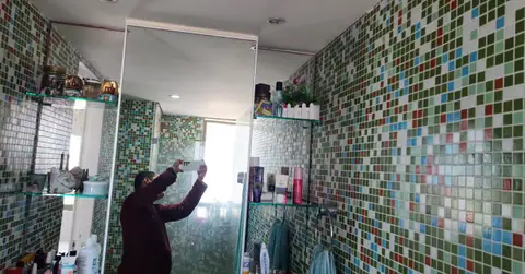 Profissional da Lucas LimpVidros limpando o box de vidro de um banheiro